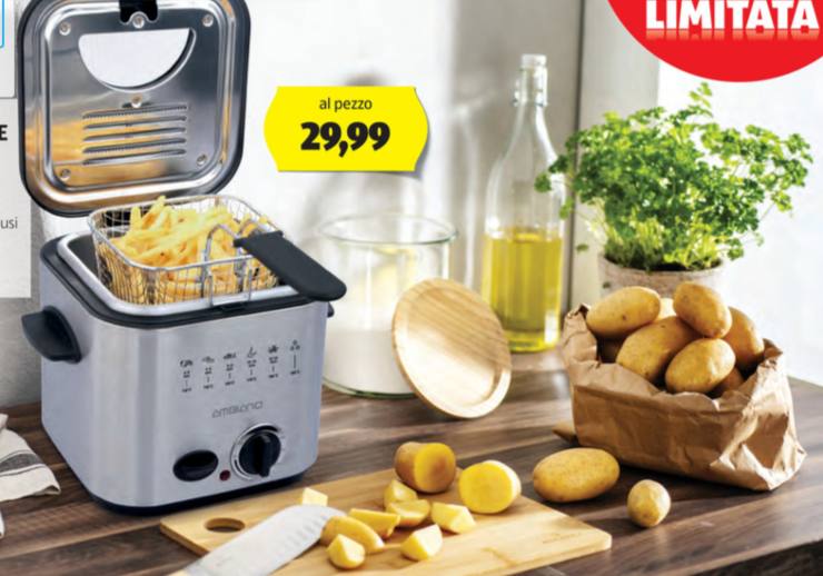 friggitrice con delle patatine dentro al cestello e accanto delle patate e una bottiglia di olio