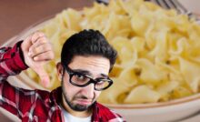 ragazzo con pasta sullo sfondo