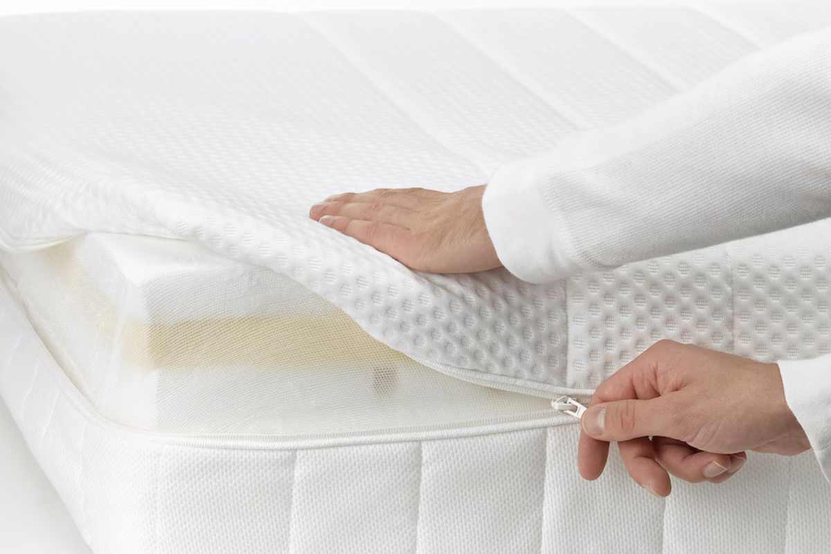mani sulla zip della fodera del materasso ÅKREHAMN Ikea