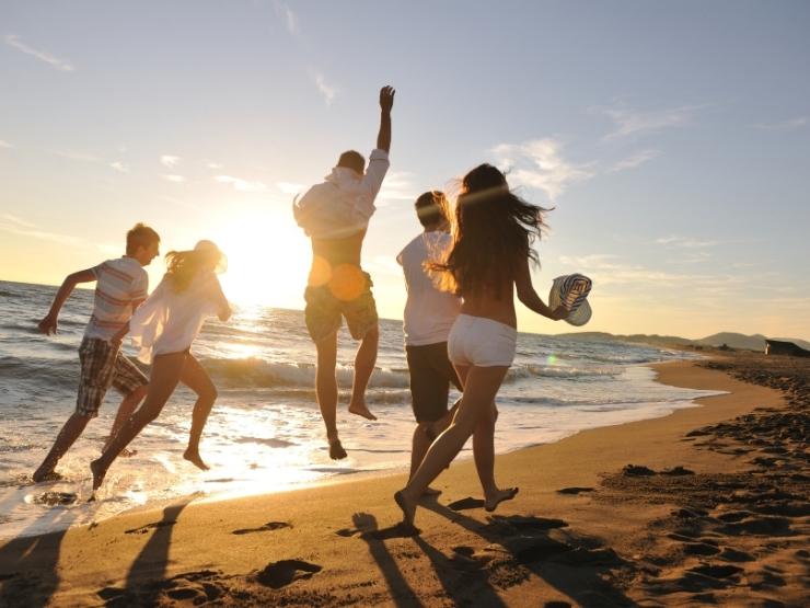 Un gruppo di amici si diverte in spiaggia al tramonto