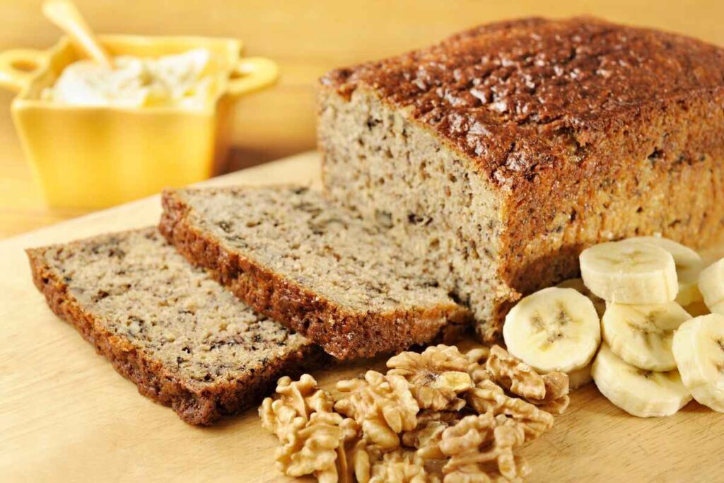 banana bread su tagliere con noci e banane