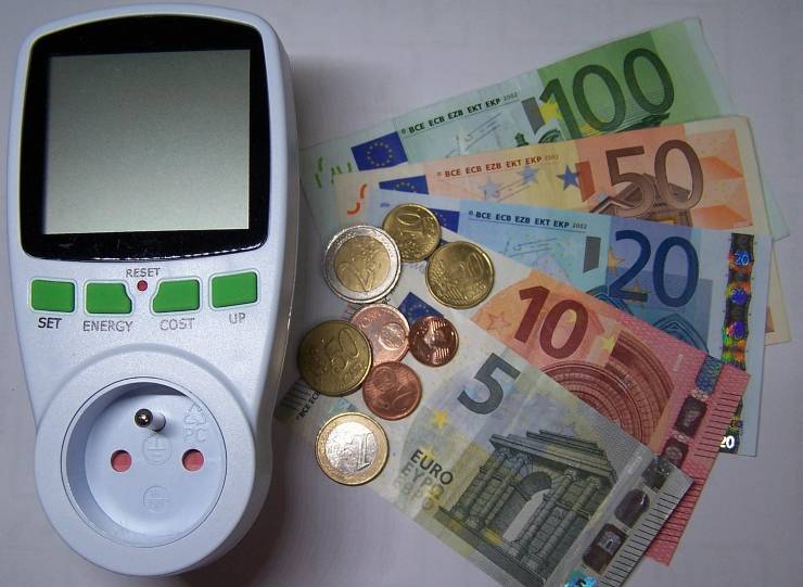 contatore dell'energia con accanto delle banconote e delle monete di euro
