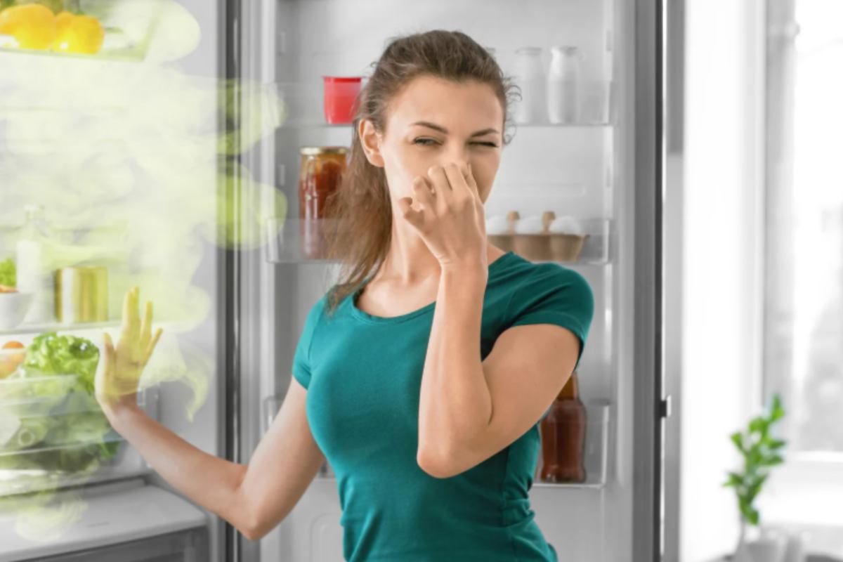 donna che si tappa il naso mentre apre il frigo