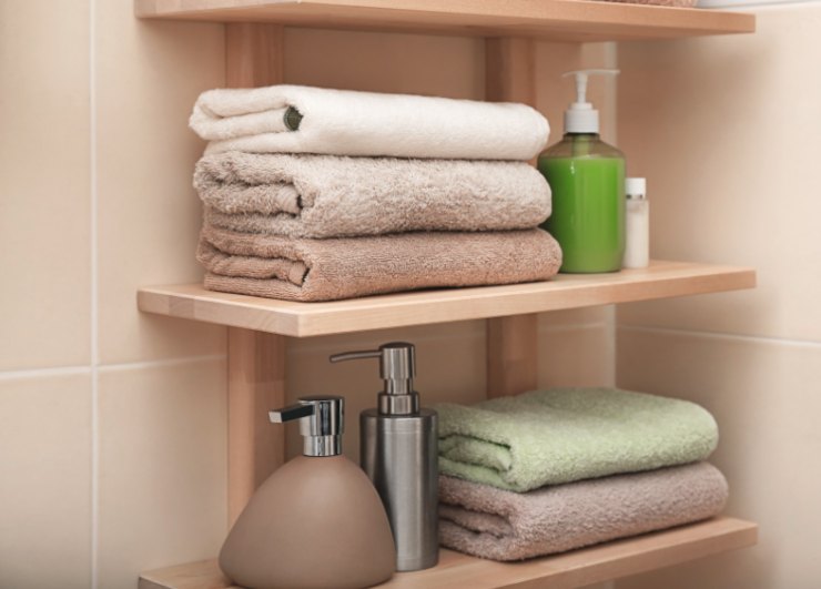 asciugamani sopra dei ripiani con accanto dei flaconi di sapone