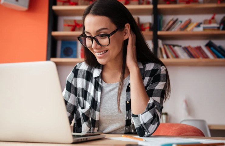 ragazza sorridente seduta di fronte al computer