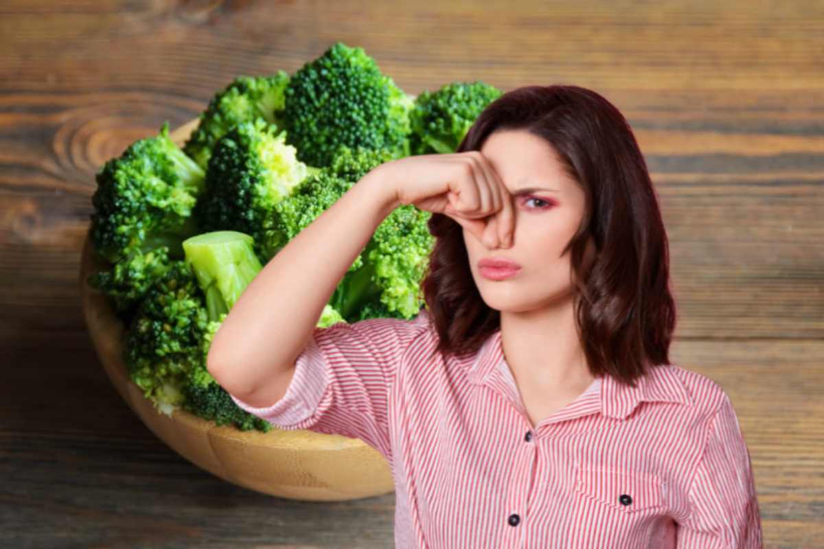 donna che si tappa il naso e dei broccoli