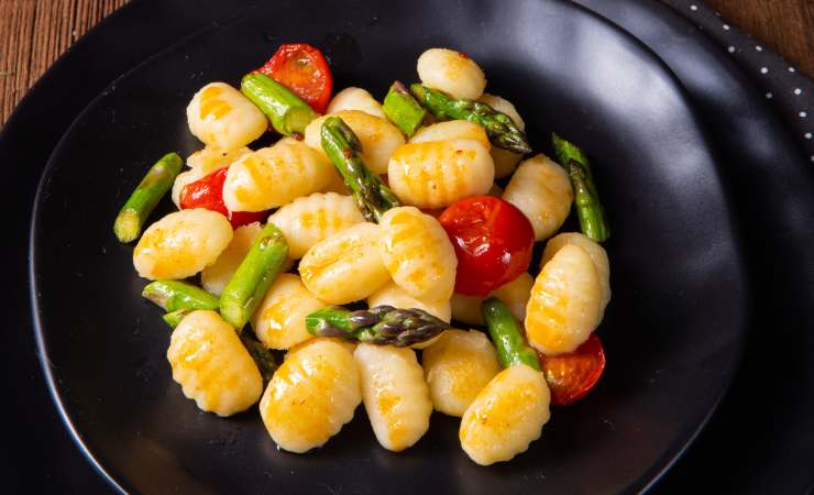 piatto di gnocchi asparagi e pomodorini