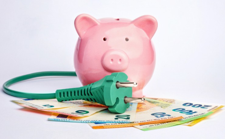 salvadanaio, presa della corrente e banconote di euro