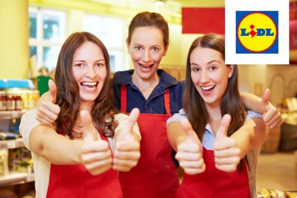 tre commesse del supermercato che sorridono con i pollici rivolti verso l'alto