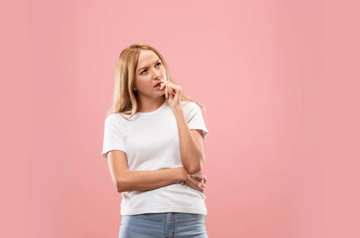 donna dubbiosa con un dito vicino alle labbra