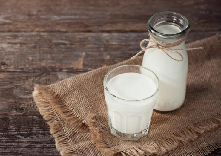 caraffa di latte e accanto bicchiere pieno di latte