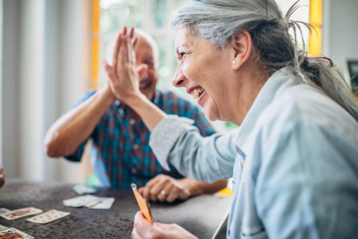 due persone anziane che ridono e si battono il 5 con le mani