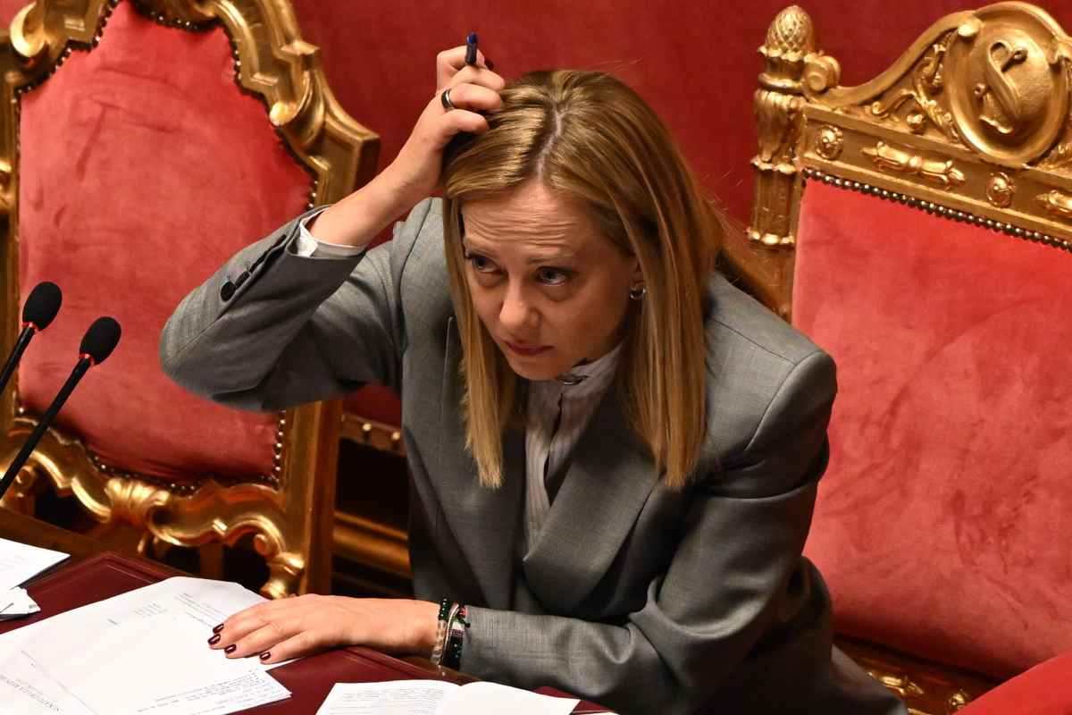 il premier giorgia meloni seduta in parlamento che si gratta la testa