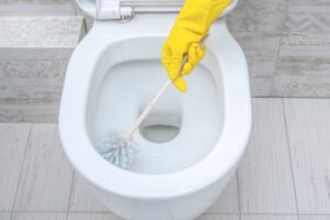 mano con guanto pulisce wc