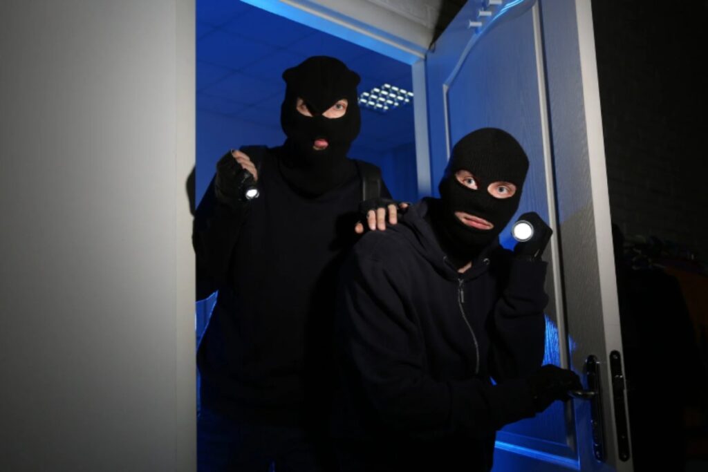 due ladri con passamontagna che entrano in una casa