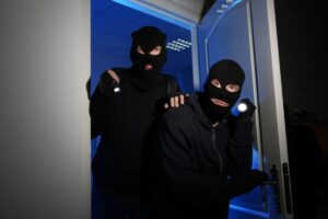 due ladri con passamontagna che entrano in una casa