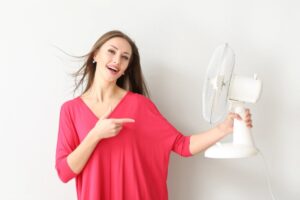 donna che tiene in mano un ventilatore portatile