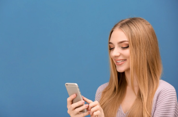 donna che sorride con il cellulare in mano