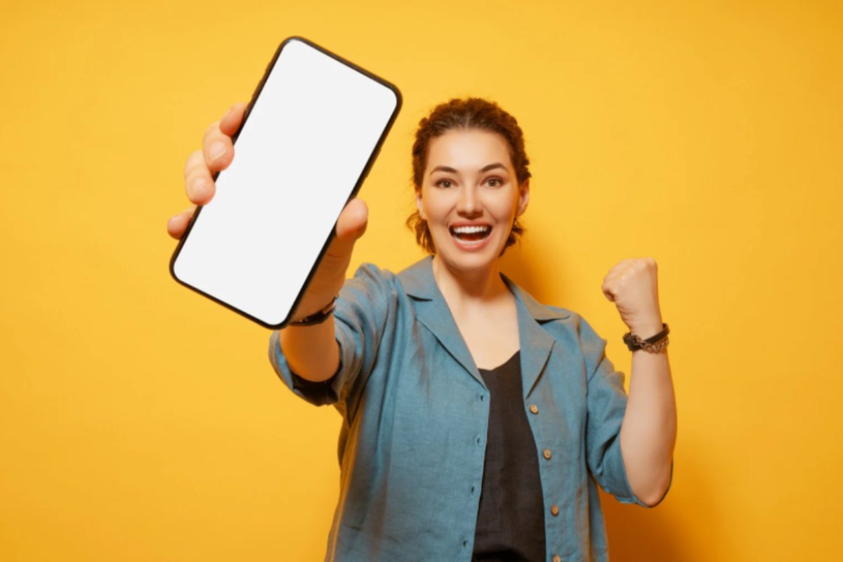 donna felice con il cellulare in mano che lo mostra