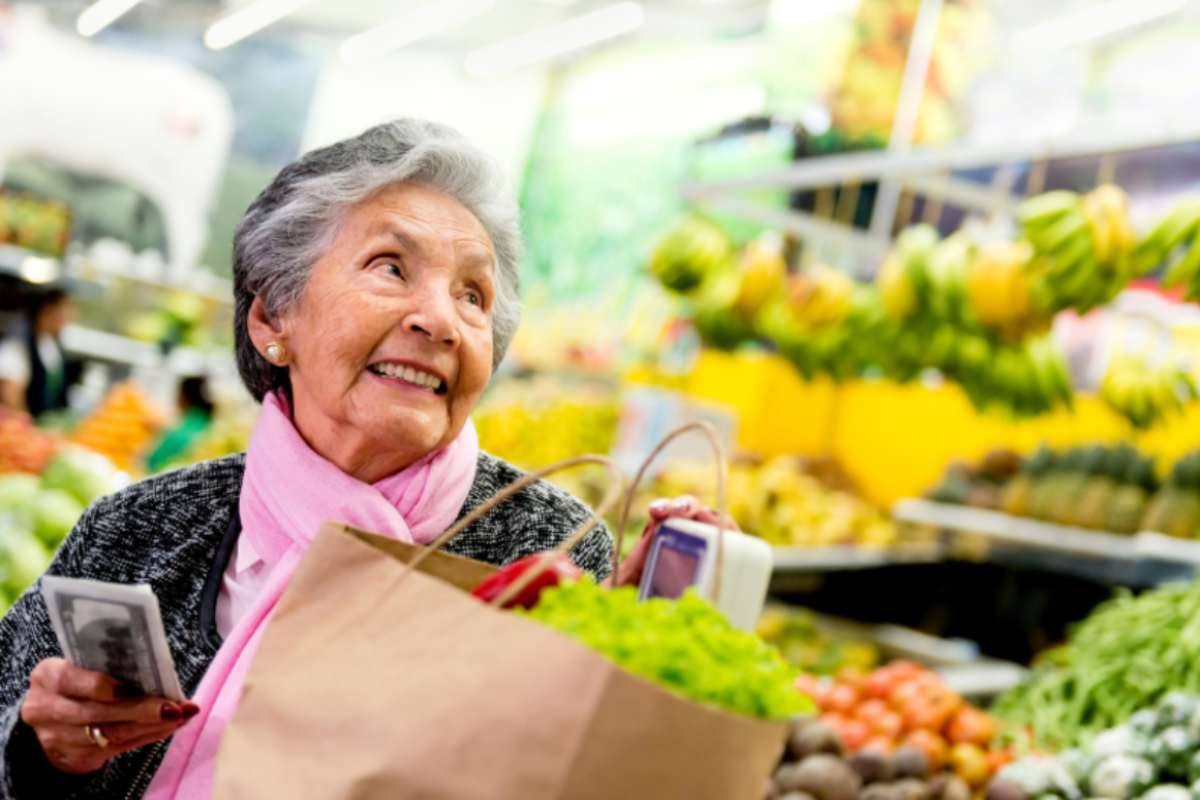 donna anziana che sorride al supermercato