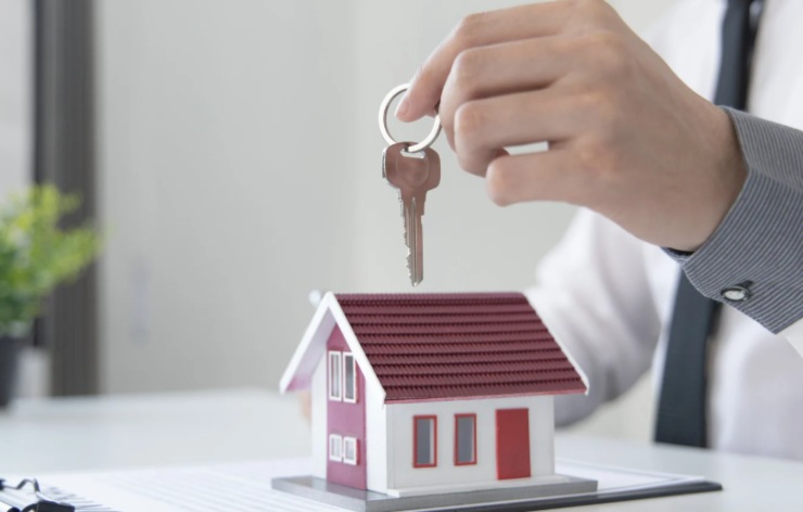 uomo con in mano delle chiavi e una casetta in miniatura