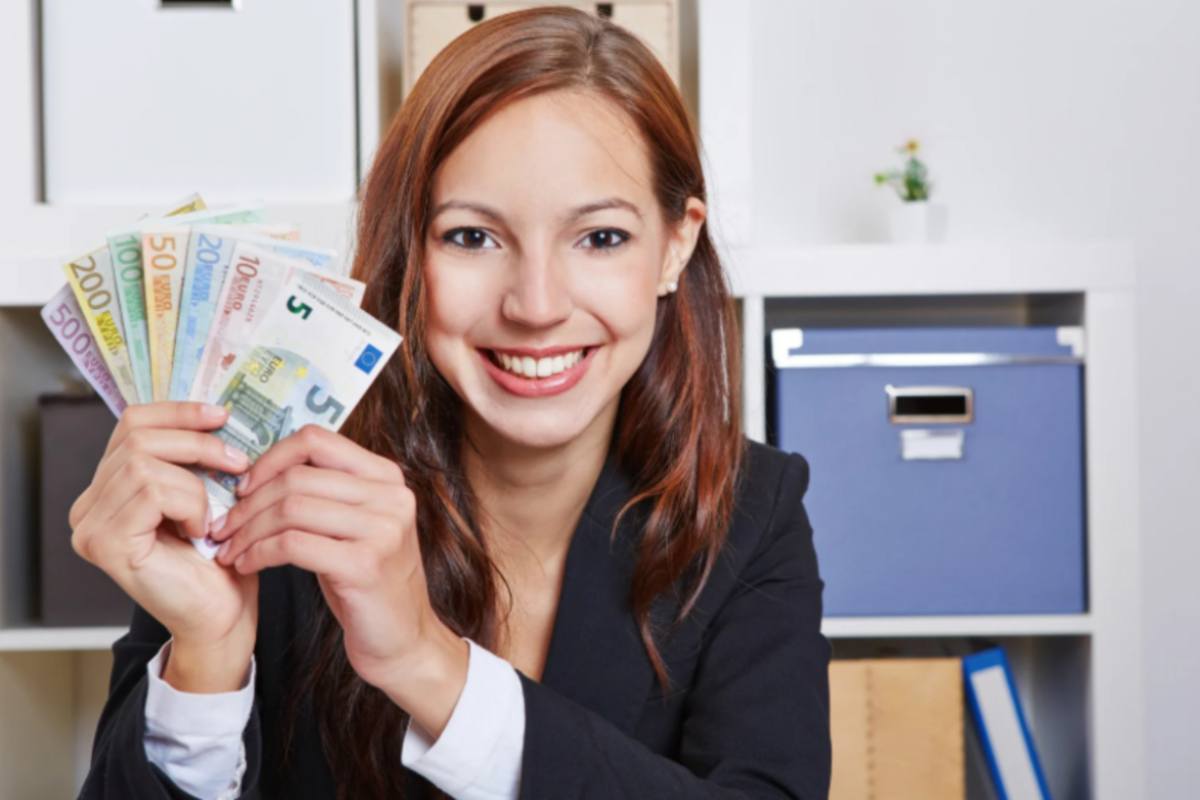 ragazza che sorride con in mano delle banconote di euro