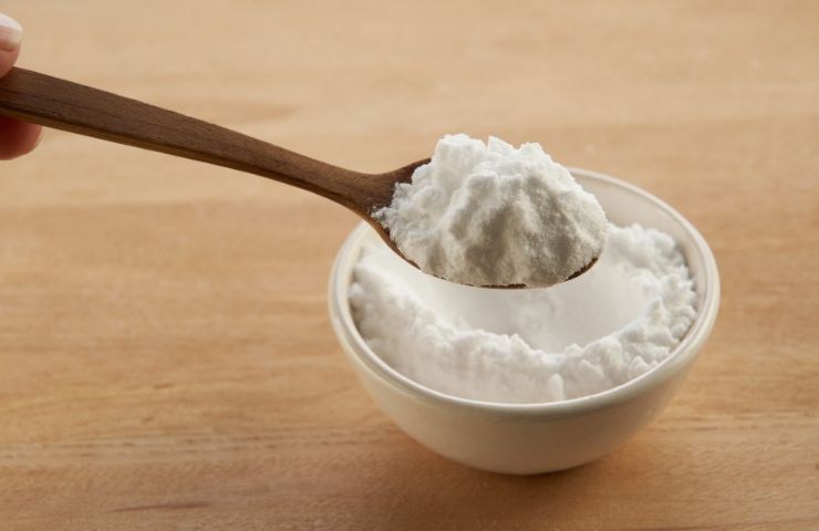 bicarbonato di sodio in ciotola con cucchiaio di legno