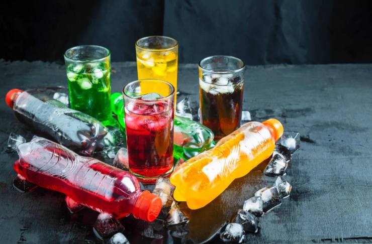 bottiglie di bevande e bevande colorate dentro a dei bicchieri