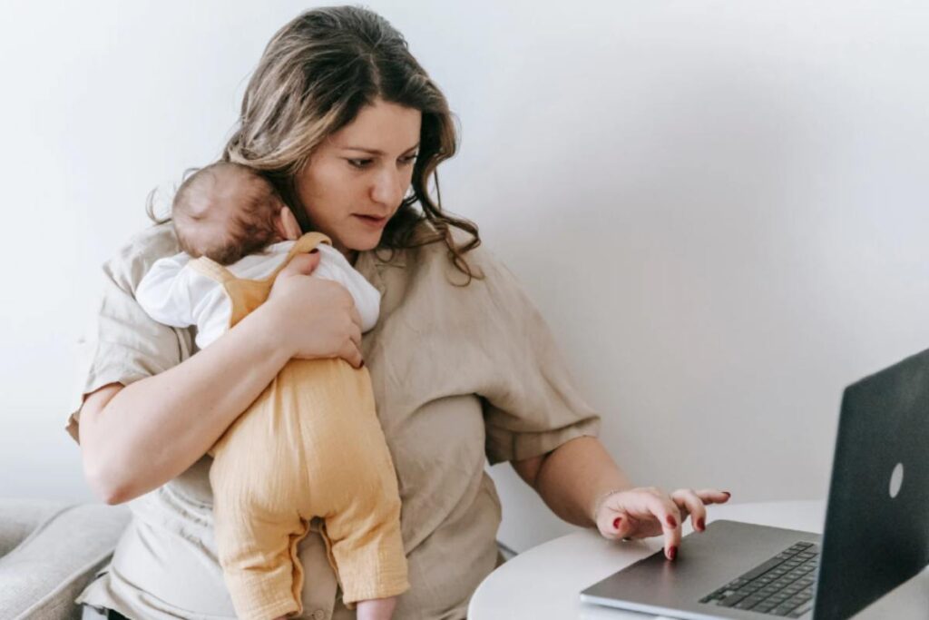 mamma al pc con bambino in braccio