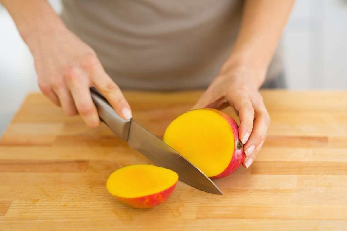 persona che taglia mango