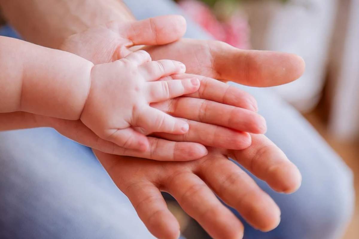 mani di adulto e di bambino