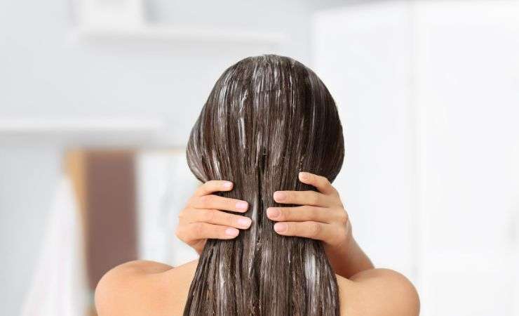 donna che si spalma crema sui capelli