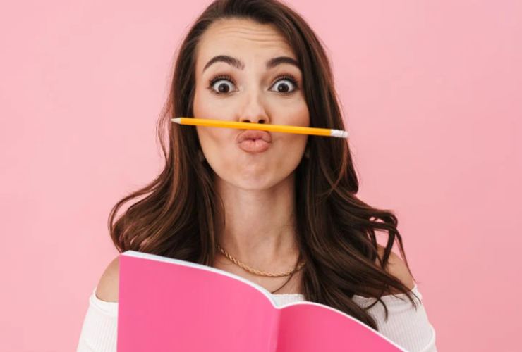 donna con matita sulle labbra e libro