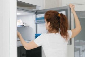ragazza che apre il congelatore
