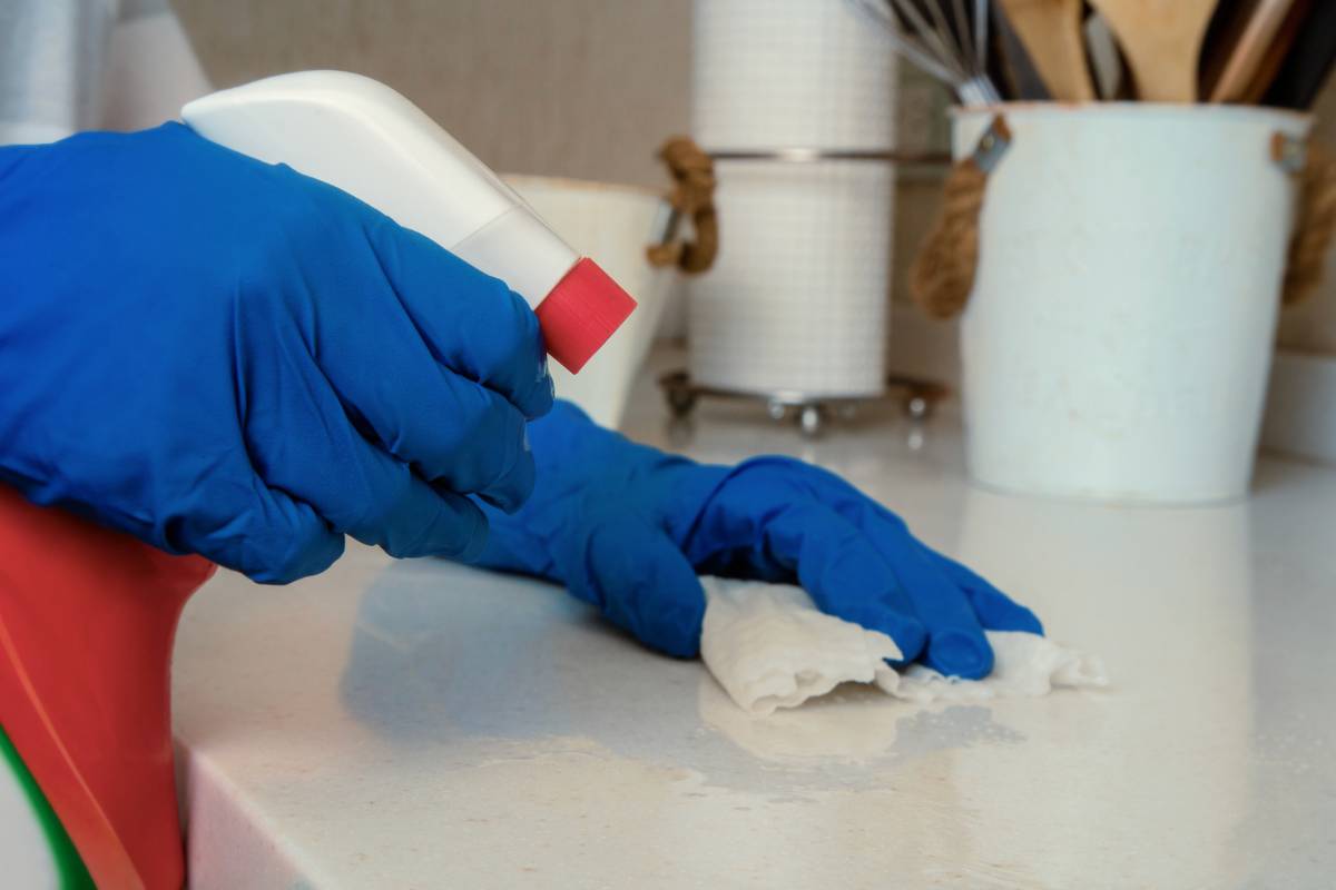 Persona che nebulizza prodotto su una superficie