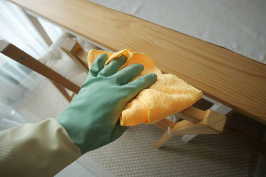 persona che pulisce mobile in legno