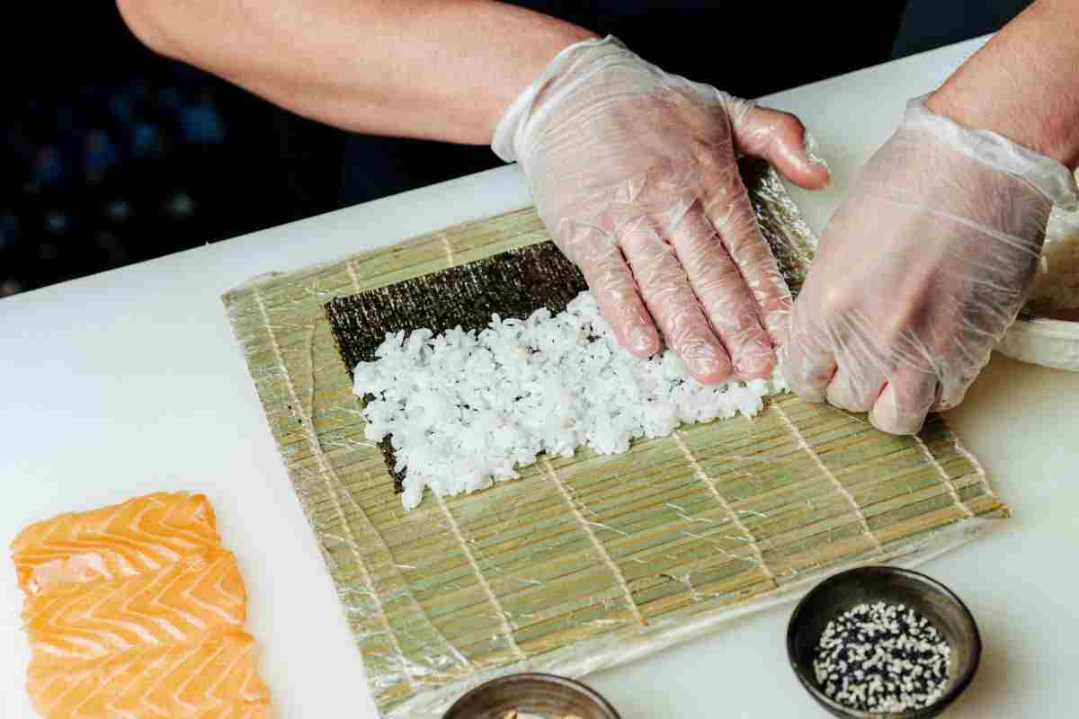 mani che preparano sushi