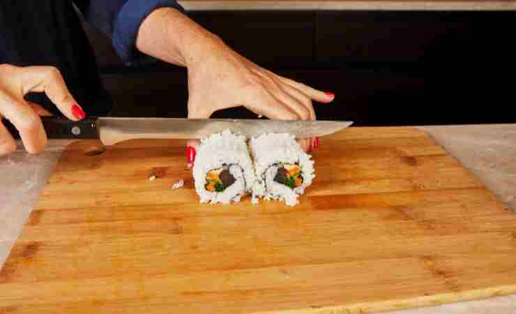 ragazza che taglia il sushi