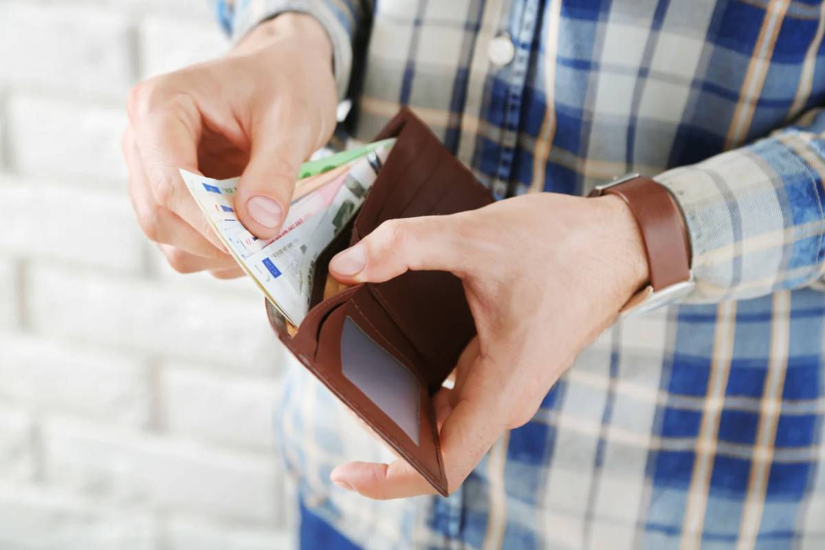 Persona che tira fuori banconote dal portafoglio