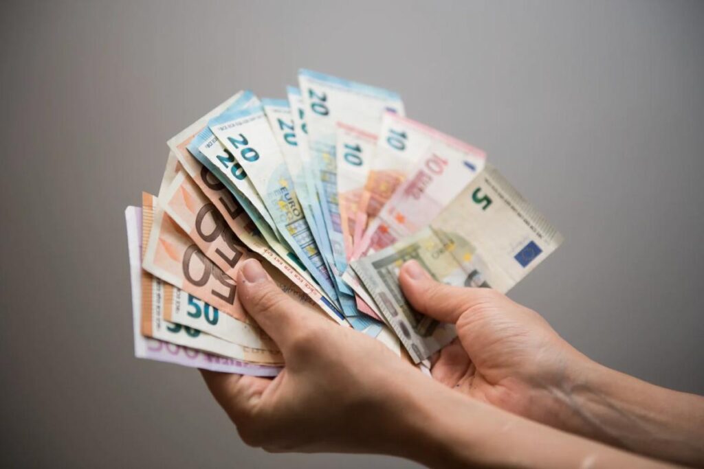 Persona che tiene in mano banconete euro