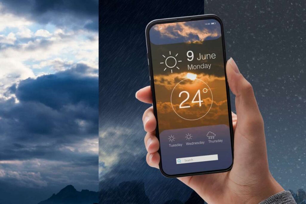 Persona che tiene in mano un cellulare con le previsioni meteorologiche