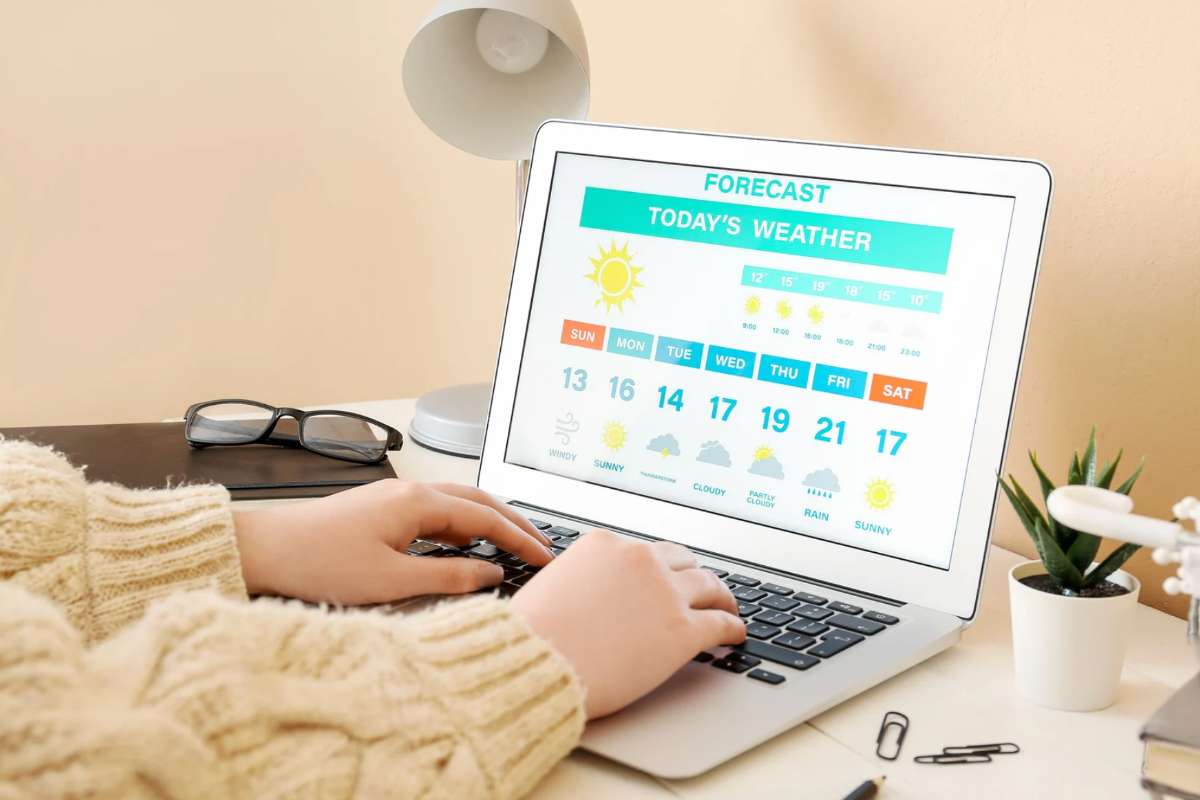 Donna che scrive al pc e osserva il meteo