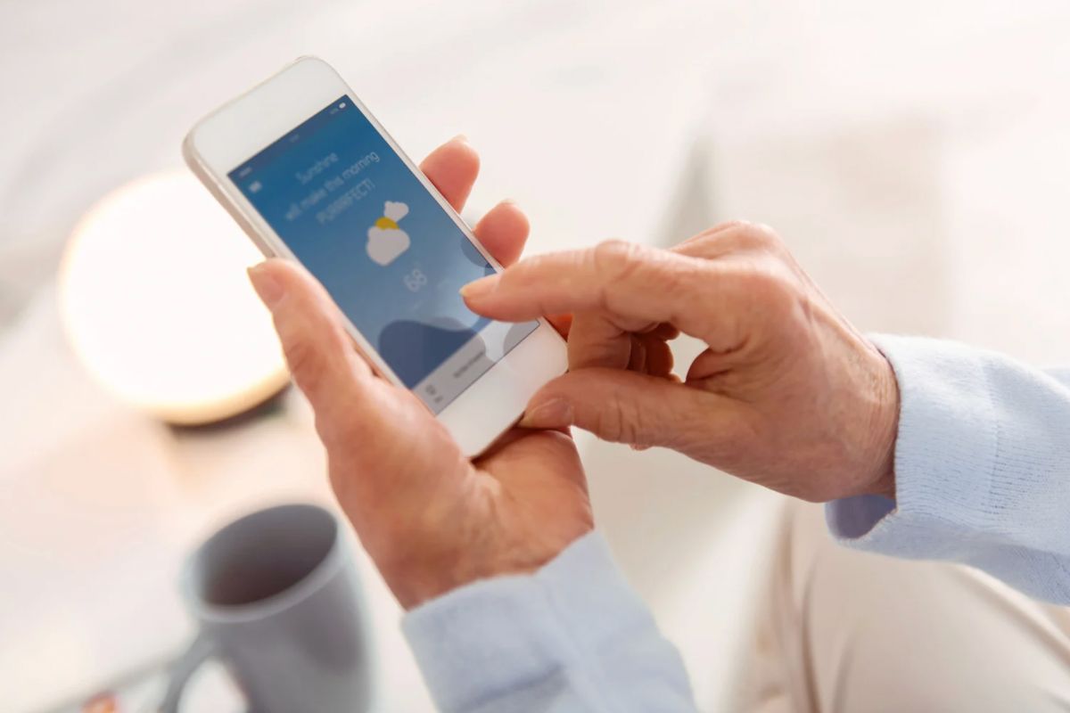 Persona con telefono in mano che controlla meteo