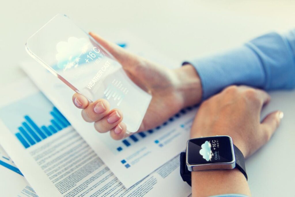 Persona con in mano smartphone e smartwatch al polso che controlla meteo