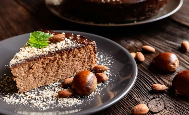 Fetta di torta in un piatto con castagne e mandorle