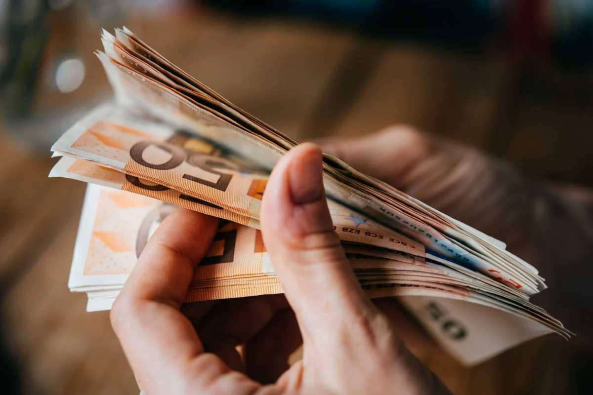 Persona con banconote da 50 euro in mano