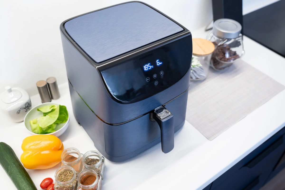 Friggitrice ad aria accesa con cibo accanto