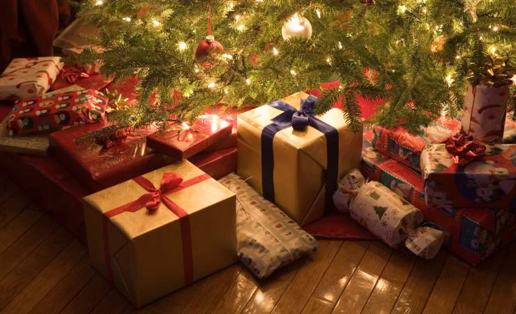 Parte inferiore albero di Natale con regali e luci