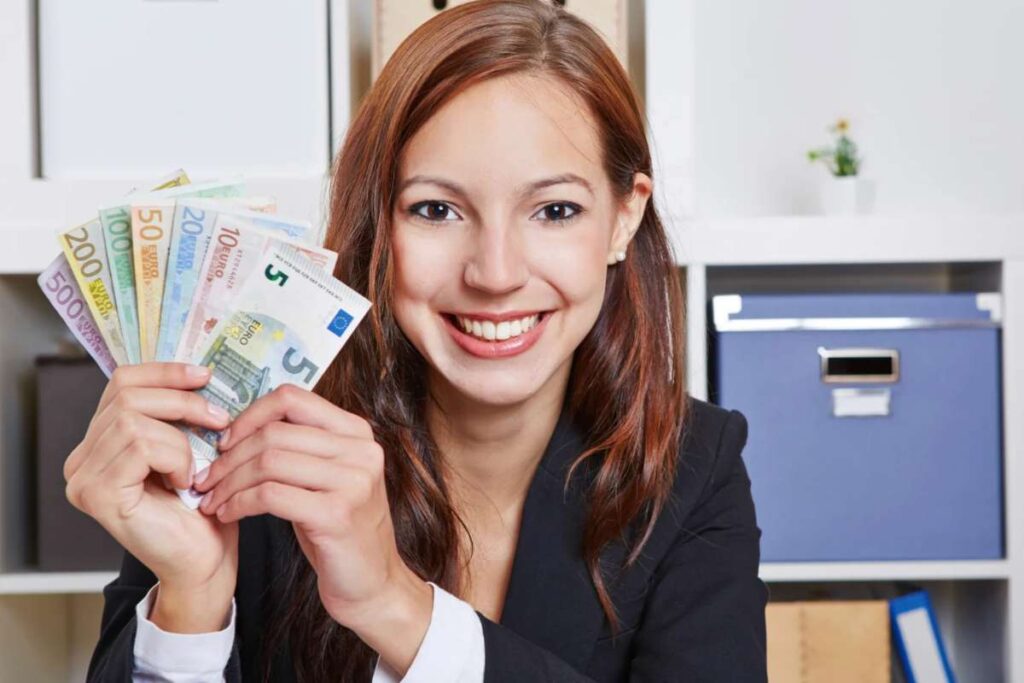 Donna sorridente con banconote euro in mano