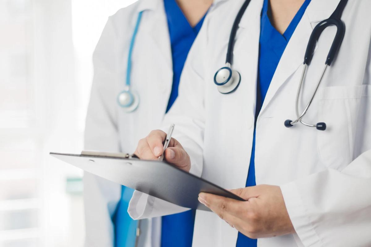 Due medici con camice e cartelline in mano